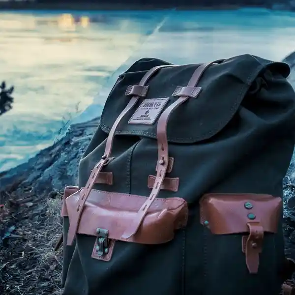 black backpack with leather details placed outdoors