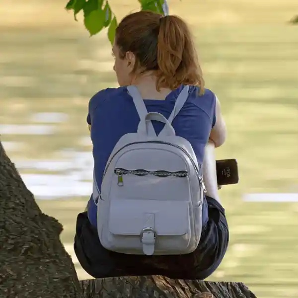 Hiker with brown backpack walking in forest